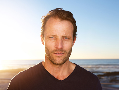 Close up portrait of middle age man standing outside staring