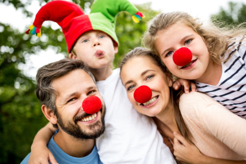 Glückliche Familie hat Spaß im Karneval in Verkleidung mit roten Nasen