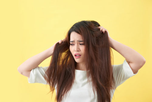 Woman holding damaged hair the hand and looking. Isolated portrait