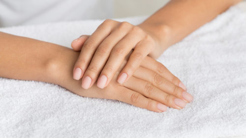 Hand care. Woman getting manicure procedure in spa salon, panorama