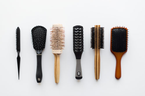 hair tools, beauty and hairdressing concept - different brushes or combs on white background